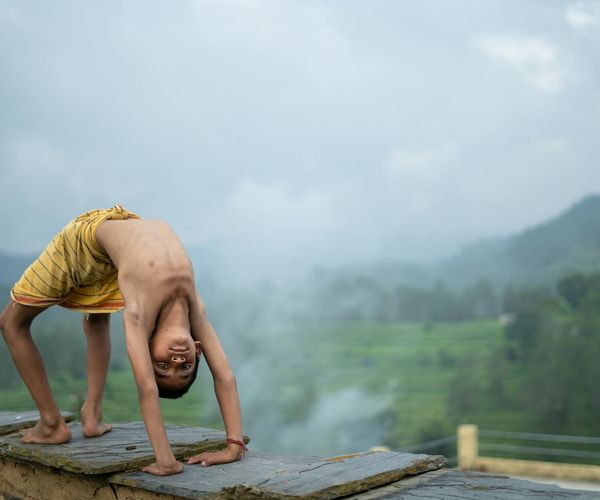 Person meditating outdoors with a serene landscape in the background.