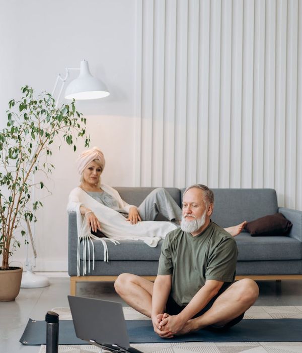 Woman in a calm yoga pose on a mat in a bright, minimalist room.